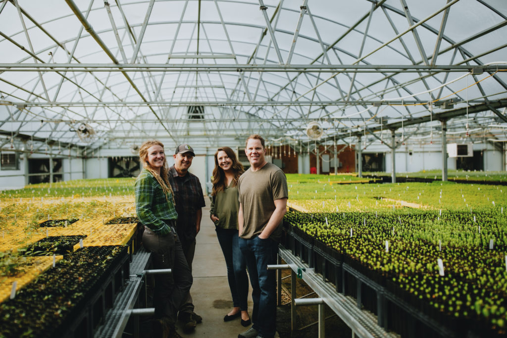 A photo of OneCanopy Founder, Kevin-Brinkman adn three staff people in the tree nursery greenhouse.