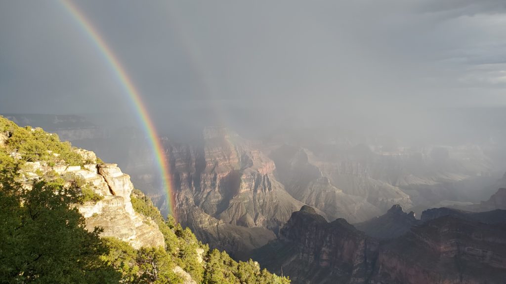 Photo of a mountain range with a rainbow