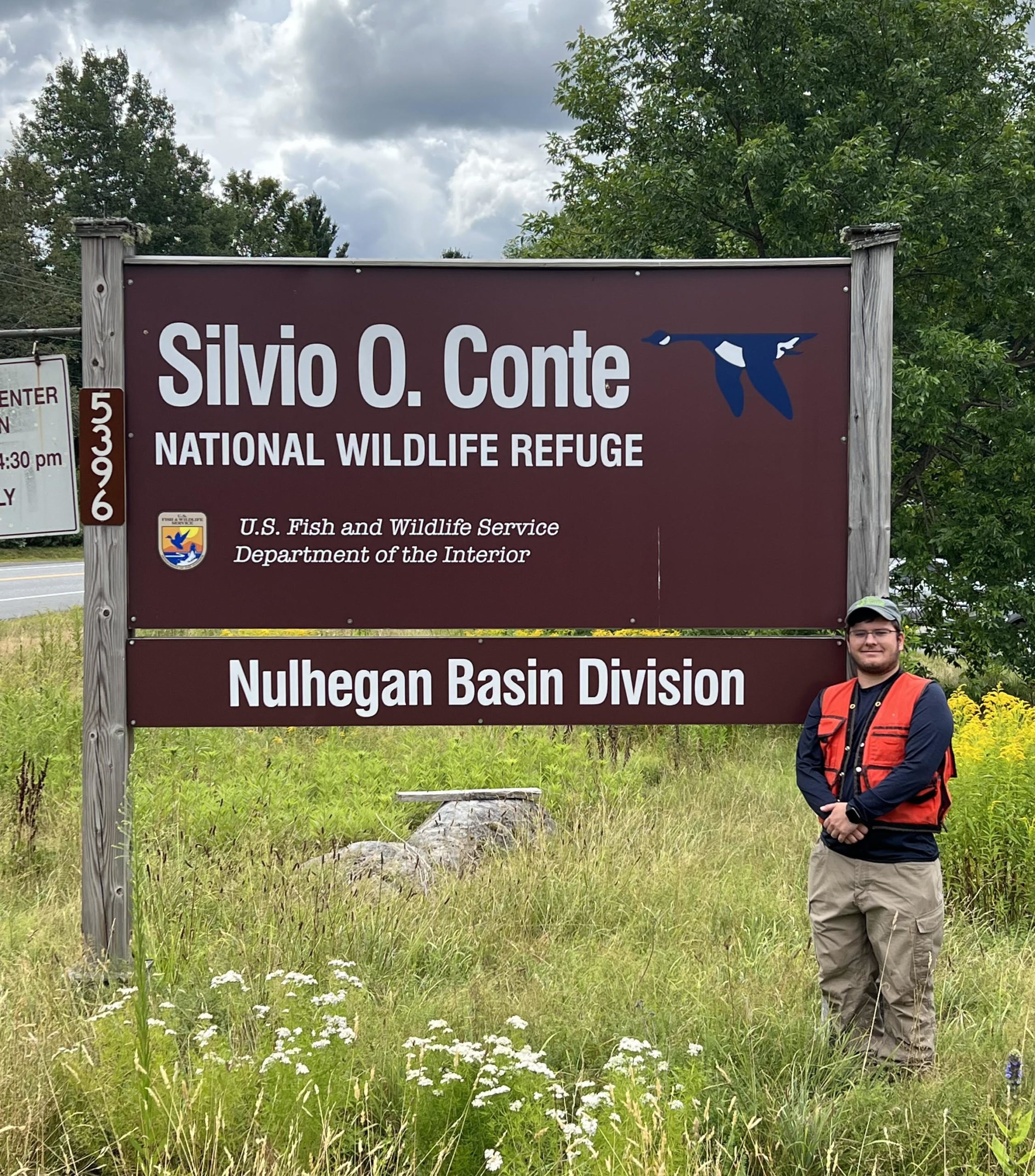 Rachel wearing a blue t-shirt in front of a Southwest landscape resembling the Grand Canyon